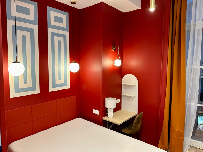 Un lit avec un mur rouge